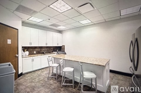 A kitchen with a counter and chairs.