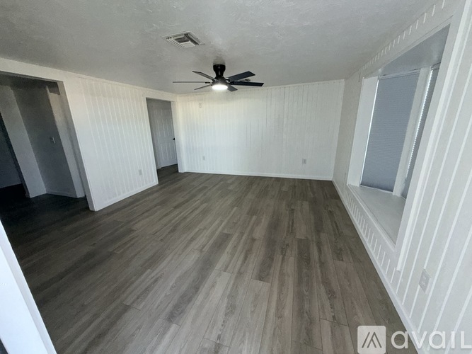 A room with wooden flooring and a ceiling fan.