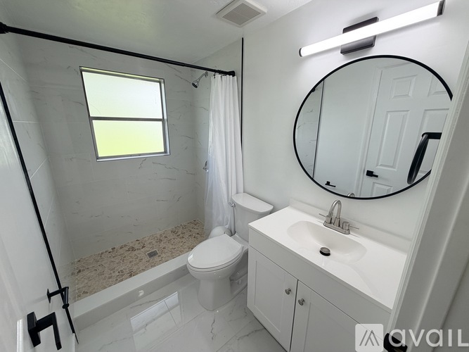 A bathroom with a toilet, sink, and a window.