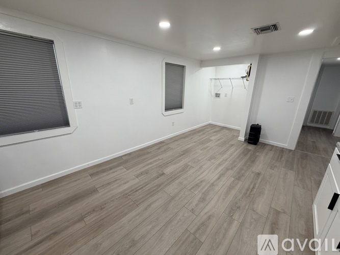 A room with wooden flooring and white walls.