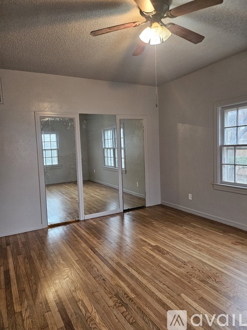 A room with wooden floors and a ceiling fan.