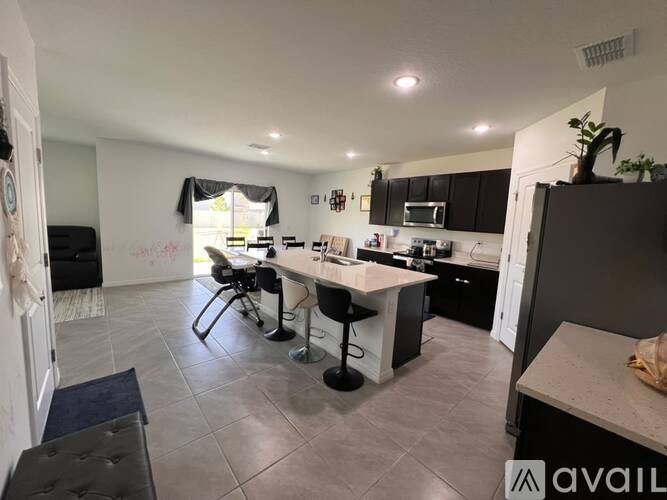 A kitchen with a dining table and chairs.