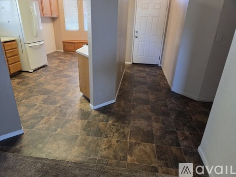 A kitchen with a white refrigerator and wooden cabinets.