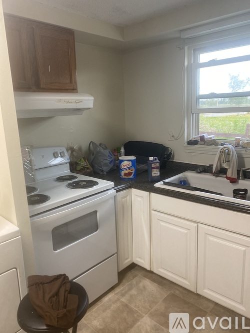 A kitchen with white cabinets and a stove top oven.