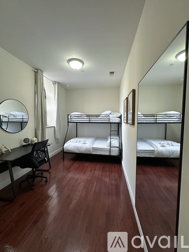 A bedroom with two beds and a desk.