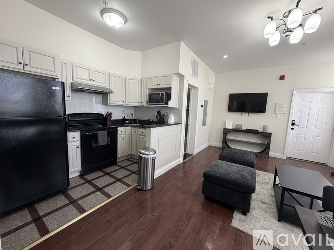 A kitchen with black appliances and white cabinets.