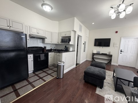 A kitchen with black appliances and white cabinets.