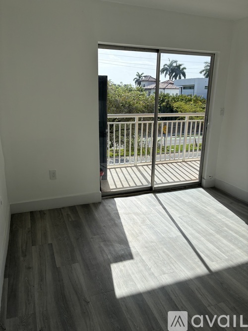 A room with a sliding glass door leading to a balcony.