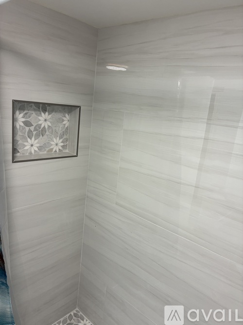 A bathroom with a white tile floor and walls.