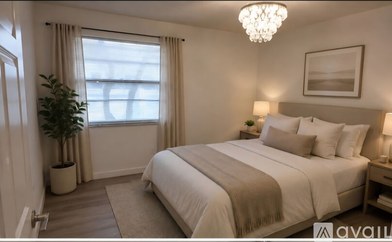 A well-lit bedroom with a large bed and a potted plant.