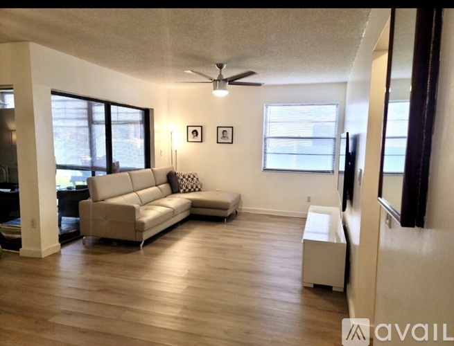 A living room with a couch, a television, and a window.