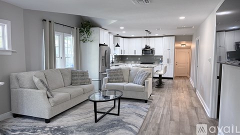 A modern living room with a grey sofa and a glass coffee table.