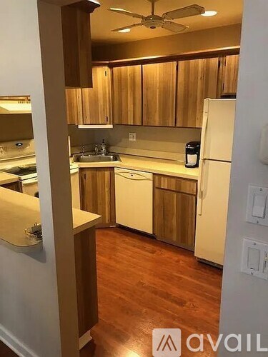 A kitchen with wooden cabinets and white appliances.