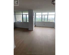 A large empty room with a view of the city.