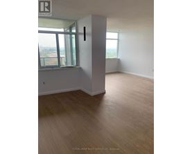 A room with wooden flooring and a window overlooking a cityscape.