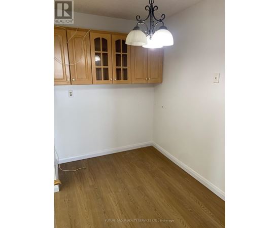 A room with wooden floors and cabinets.