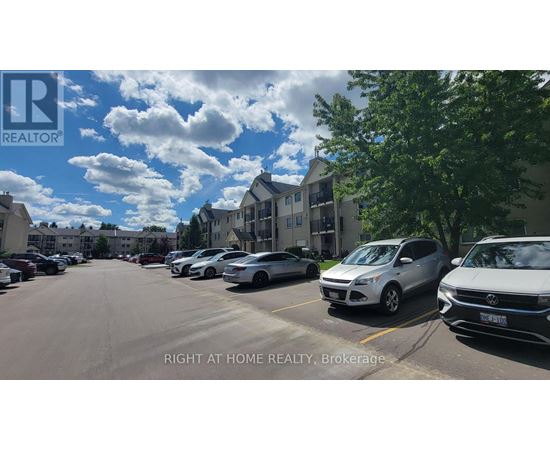 A parking lot with cars and a building in the background.