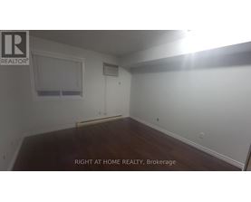 A room with a window and a wooden floor.