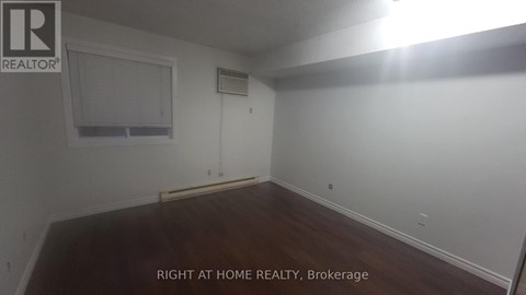 A room with a window and a wooden floor.