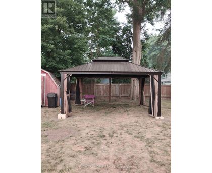 A gazebo is in the middle of a grassy area.