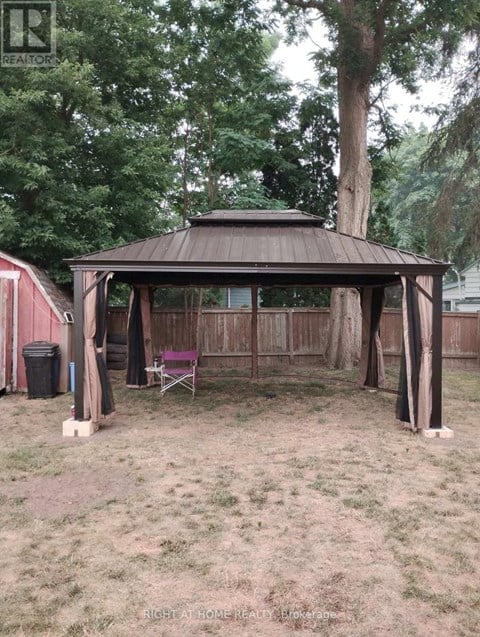 A gazebo is in the middle of a grassy area.
