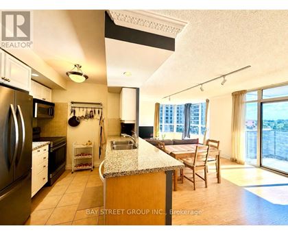 A kitchen with a refrigerator, sink, and a dining table with chairs.