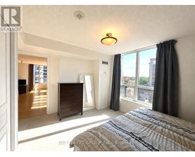 A bedroom with a large bed and a dresser is shown.