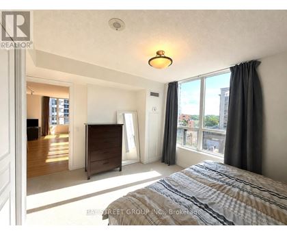 A bedroom with a large bed and a dresser is shown.