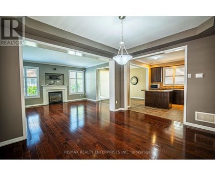 A large open living room with wood floors and a fireplace.