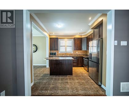 A kitchen with a brown island in the middle.