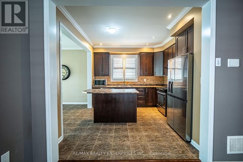 A kitchen with a brown island in the middle.