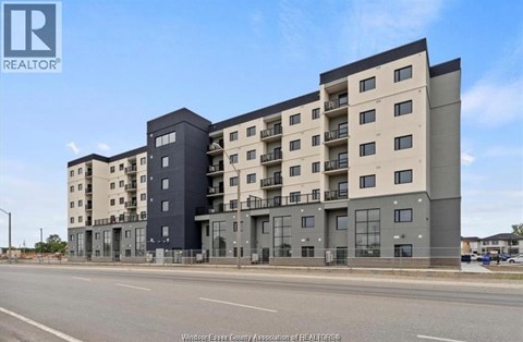 A large, modern apartment building with balconies on the upper floors.