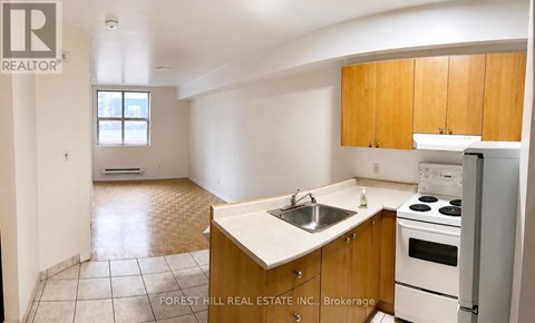 A kitchen with wooden cabinets and a white stove top oven.