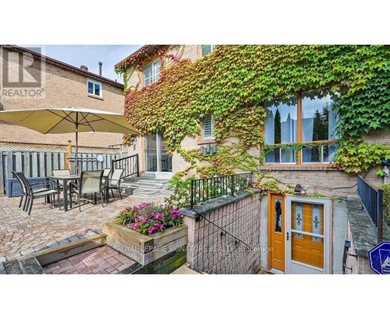 A patio with a table and chairs is surrounded by a wall covered in green vines.