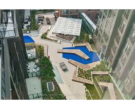 A view of a courtyard with a pool and a building in the background.