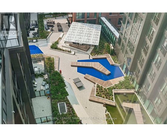 A view of a courtyard with a pool and a building in the background.