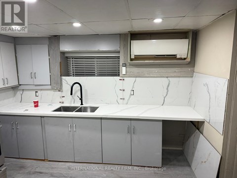 A kitchen with a marble counter top and stainless steel cabinets.