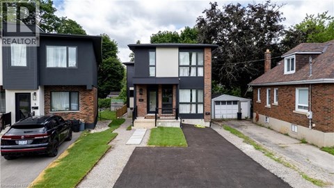 A black car is parked in front of a house with a sign that says "REALTOR".