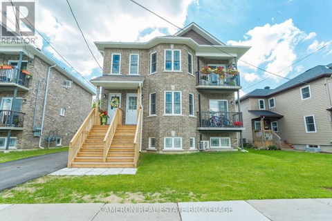 A large house with a balcony and a staircase leading to the front door.
