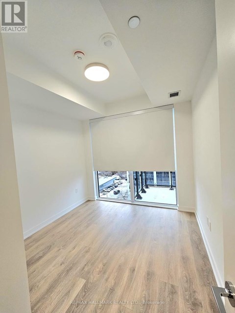 A room with a sliding glass door leading to a balcony.