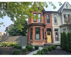 A brick house with a yellow door and a sign that says Freeman Real Estate LTD Brokerage.