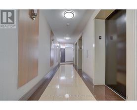 A hallway with a light on the ceiling and doors on the right.