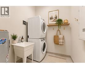 A small white sink is in a laundry room with a washer and dryer.
