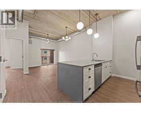 A kitchen area with a white counter and grey cabinets.