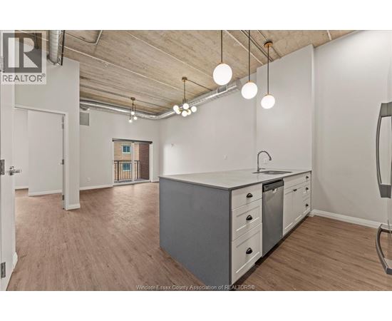 A kitchen area with a white counter and grey cabinets.