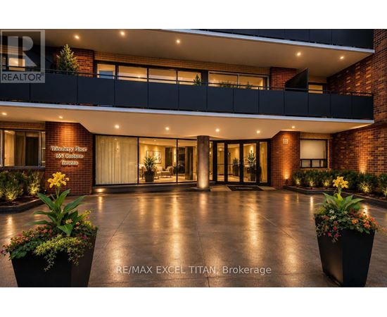The image shows the front entrance of a building with a sign that reads "RE/MAX EXCEL TITAN Brokerage".