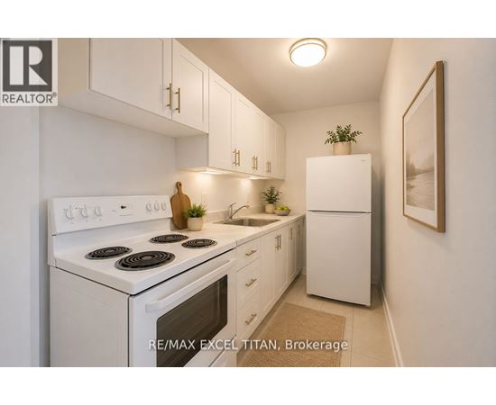 A white kitchen with a stove top oven and a refrigerator.