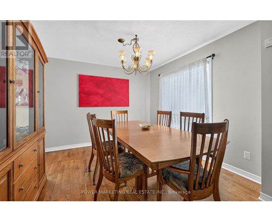 A dining room with a wooden table and chairs.