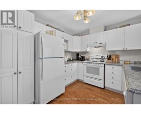 A kitchen with white cabinets and appliances.