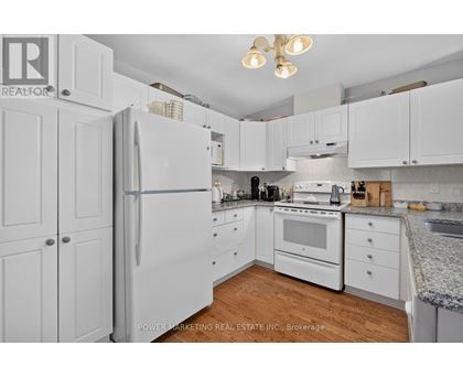 A kitchen with white cabinets and appliances.